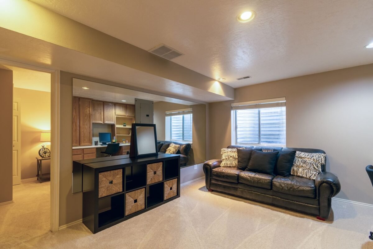 Finished basement living room with a leather sofa and warm lighting