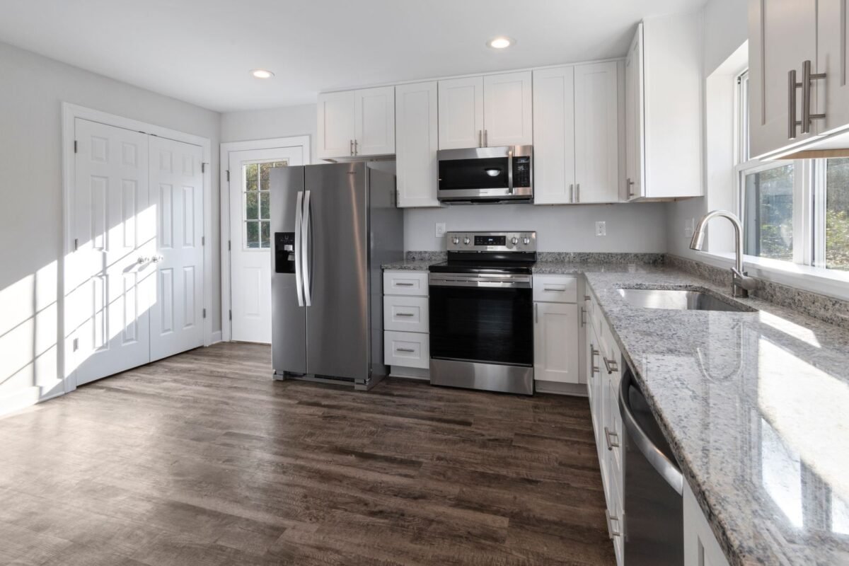 Renovated kitchen with white shaker cabinets, stainless steel appliances and wood flooring