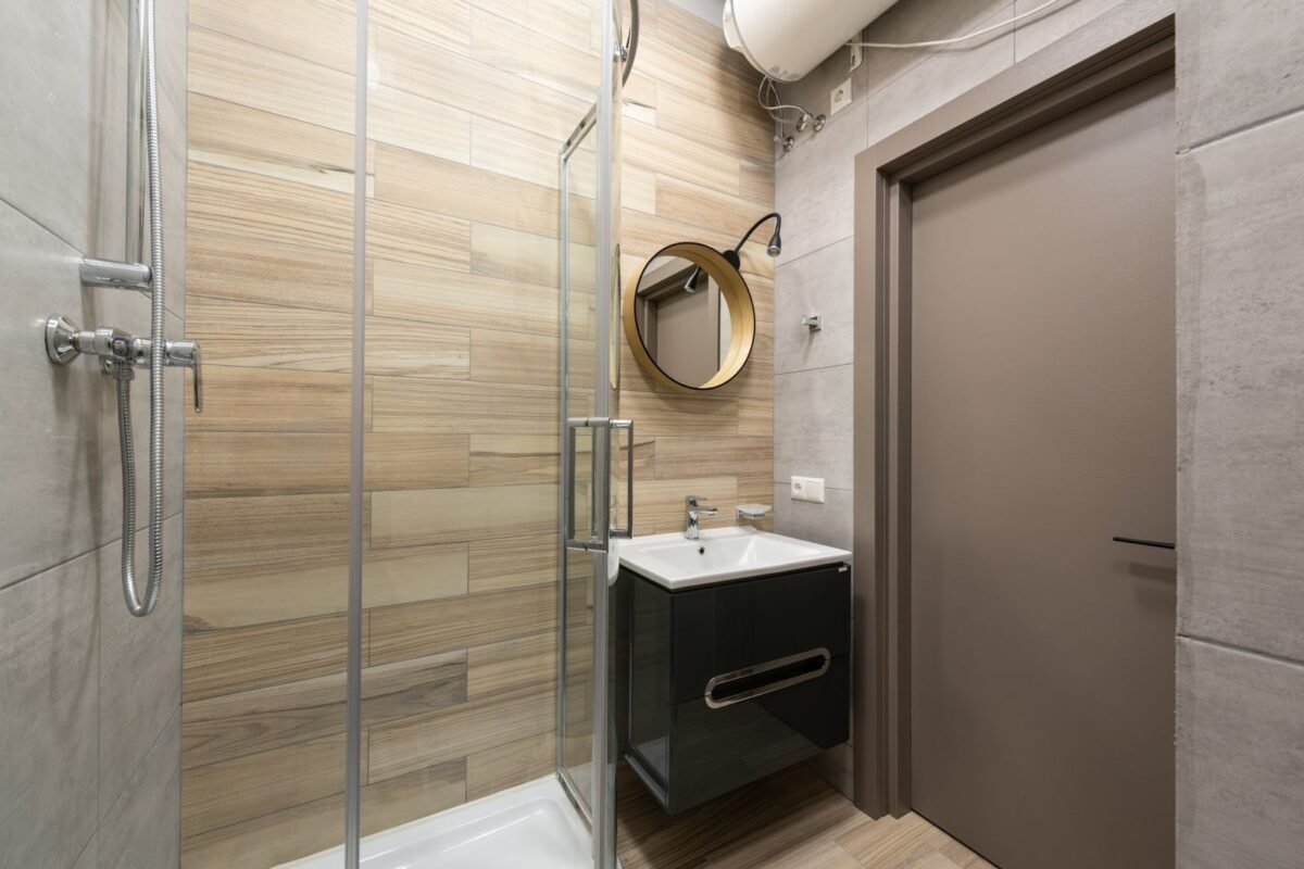Small modern bathroom with a glass-walled walk-in shower and a compact ceramic sink